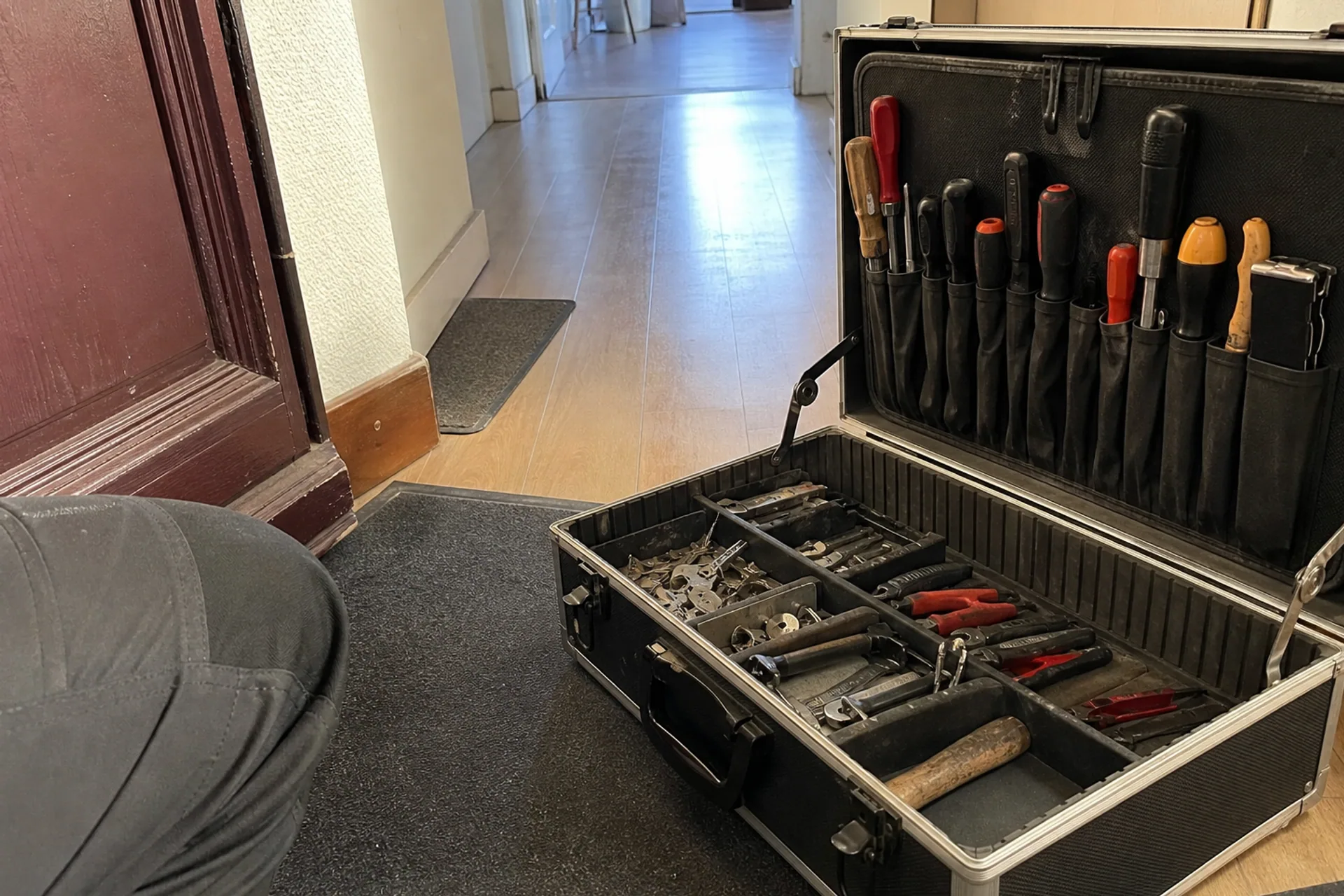 mallette outillage serrurerie ouverte sur le palier